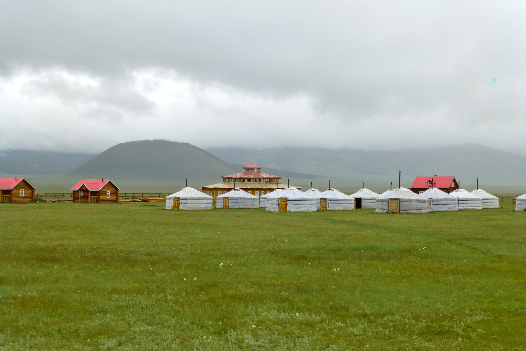 Jurtencamp in der Mongoei, im Hintergrund der Vulkan